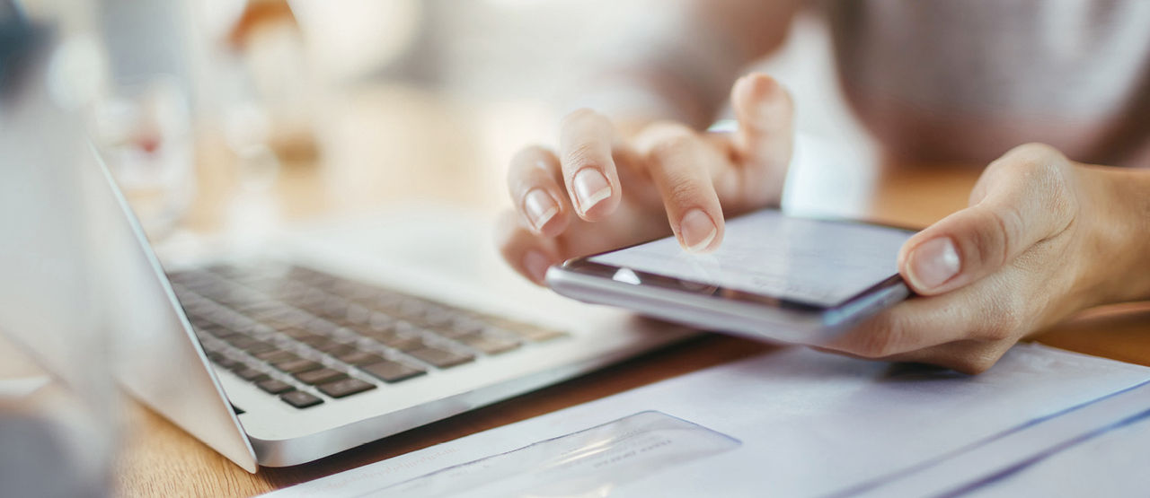Person doing administrative tasks with a laptop and a tablet